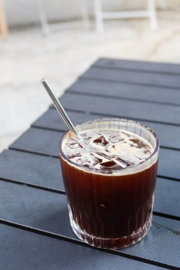 Piknik masasının üzerine ekolojik paslanmaz çelik pipetle fotokopi alanı olan buzlu Americano sade bir kahve koyun.