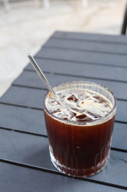 Piknik masasının üzerine ekolojik paslanmaz çelik pipetle fotokopi alanı olan buzlu Americano sade bir kahve koyun.