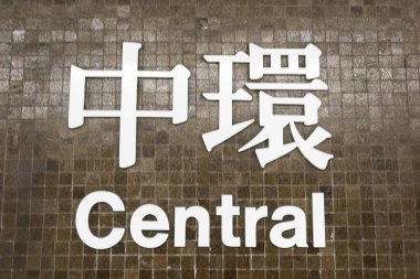 Merkez İstasyon, Hong Kong - 25 Ocak 2025: Merkezi MTR tabelası Çince ve İngilizce yazılmış koyu kahverengi duvar, yoğun bir istasyon..