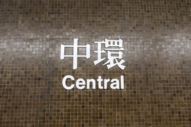 Merkez İstasyon, Hong Kong - 25 Ocak 2025: Merkezi MTR tabelası Çince ve İngilizce yazılmış koyu kahverengi duvar, yoğun bir istasyon..