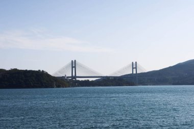 Tsing Ma Köprüsü, Hong Kong - 29 Ocak 2025: Mavi gökyüzü ve okyanus ile deniz köprüsü. Hong Kong Uluslararası Havalimanı ve şehrini birbirine bağlıyor..