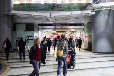 Tsuen Wan, Hong Kong - 18 Mar 2025: Birçok yolcu gece MTR tren istasyonuna girip çıkıyor.