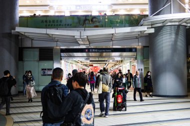 Tsuen Wan, Hong Kong - 18 Mar 2025: Birçok yolcu gece MTR tren istasyonuna girip çıkıyor.
