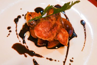 Karamelli elma ve beyaz tabakta siyah sirke sosu ile foie gras yakın çekim