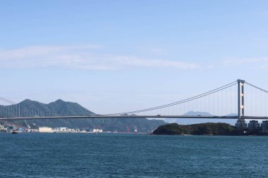 Tsing Yi, Hong Kong - 29 Ocak 2025: Mavi gökyüzü ve gemi ile denizde Tsing Ma Köprüsü