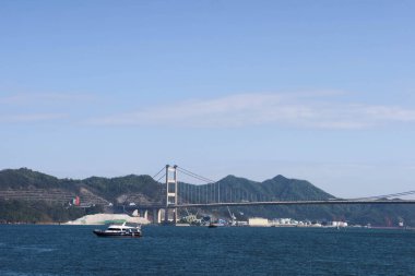 Tsing Yi, Hong Kong - 29 Ocak 2025: Mavi gökyüzü ve gemi ile denizde Tsing Ma Köprüsü