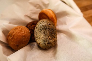 Fotokopi alanı olan bir sepetteki beyaz parşömen kağıdına yerleştirilmiş farklı ekmek çeşitlerini kapat.