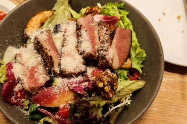 Füme ördek göğsü salatasının üzerine ceviz, elma ve peynir serpilmiş fotokopi alanı serpilmiş.