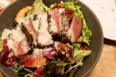 Füme ördek göğsü salatasının üzerine ceviz, elma ve peynir serpilmiş fotokopi alanı serpilmiş.