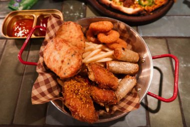 Karışık Tayland aperatiflerine yakın. Kızarmış balık köfteleri, patates kızartmaları, soğan halkaları, börekler ve tatlı ve ekşi soslu tavuk kanatları dahil. 