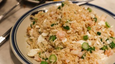 Altın rengi Çin yumurtası, kızarmış pirinç, yumurta beyazı, karides ve sebze tabağı.