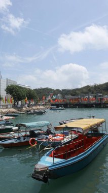 Peng Chau, Hong Kong - 20 Nisan 2025: Peng Chau Rıhtımı kıyısında park etmiş balıkçı tekneleri, arkada Peng Chau Market binası