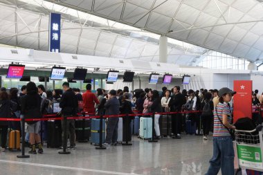 Hong Kong Uluslararası Havaalanı, Chek Lap Kok, Hong Kong - 7 Aralık 2024: birçok turist bagaj teslimatı için havaalanında kuyruğa girdi