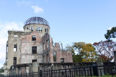 Hiroşima, Japonya - 8 Aralık 2024: Eski İl Endüstriyel Tanıtım Salonu Hiroşima Barış Anıt Parkı ve UNESCO Dünya Mirası Alanı olarak belirlendi. Sonbaharda sarı yapraklı Atom Bombası Kubbesi