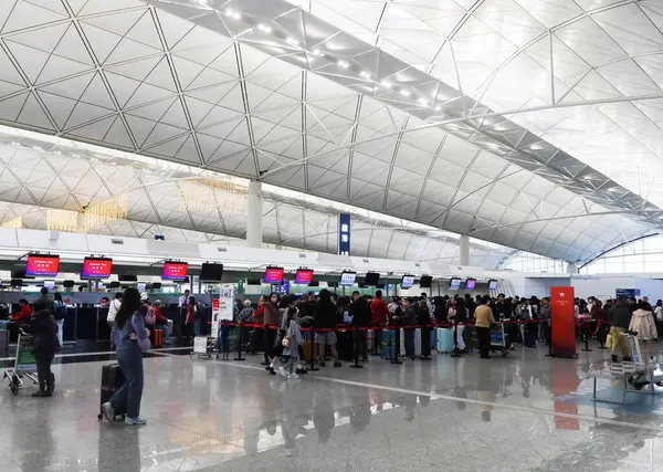 Hong Kong Uluslararası Havaalanı, Chek Lap Kok, Hong Kong - 7 Aralık 2024: birçok turist bagaj teslimatı için havaalanında kuyruğa girdi