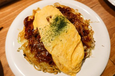 Japon Hiroşima usulü yumurta omletine yakın çekim tavada erişte (Hiroshima Style Okonomiyaki) 