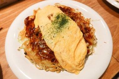 Japon Hiroşima usulü yumurta omletine yakın çekim tavada erişte (Hiroshima Style Okonomiyaki) 