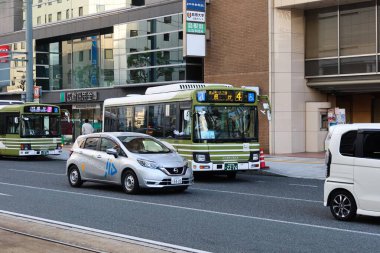 Hiroşima, Japonya- 11 Aralık 2024: yol ve binaların arasından geçen otobüs ve araçlarla dolu yol.