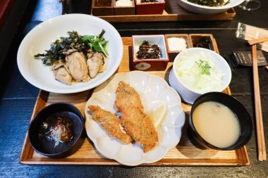 Japon yemek takımını dolgun kızarmış istiridye, taze çiğ istiridye, marine edilmiş sebze, soya sosu, tuz, pirinç ve miso çorbası ile kaplayın.