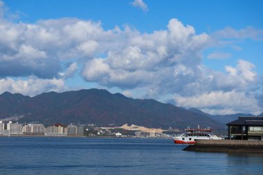 Miyajima Adası, Hiroshima - 9 Aralık 2024: Miyajima iskelesi Hiroşima 'ya ve karşı adaya bağlı binalar