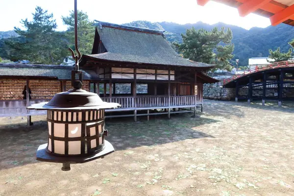 Hirabutai (Güverte) -Takabutai (Yükseltilmiş Sahne), Itsukushima Tapınağı, Miyajima Adası, Hiroşima, Japonya - 9 Aralık 2024: gündüz vakti fener ışığı asılı olan türbe ahşap bina