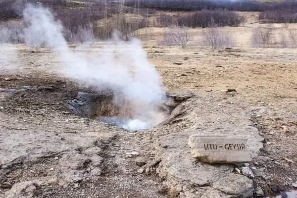 Litli Geysir, İzlanda, Avrupa - 20 Mar 2016: Yandan duman ve konum işareti gelen küçük sıcak kaynak