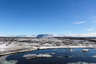 Thingvellir Ulusal Parkı mavi gökyüzü gününde, göl buz ve karla kaplı Mart ayında