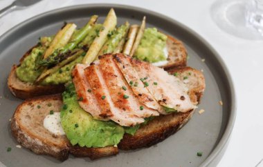 Avokado ile iki ekşi ekmek ve fotokopi alanı ile ızgara tavuk göğsü.