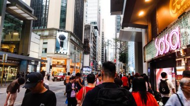 Queen 's Road, Central, Hong Kong - Mayıs 12025: her iki tarafta dükkanları olan insanlar cadde boyunca yürüyor