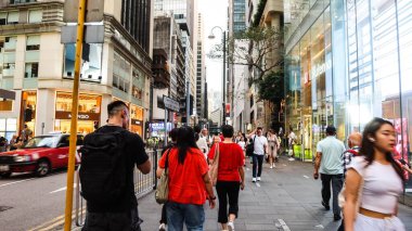 Queen 's Road, Central, Hong Kong - Mayıs 12025: her iki tarafta dükkanları olan insanlar cadde boyunca yürüyor