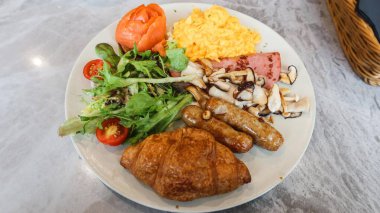 Çırpılmış yumurta, salata, vişneli domates, füme somon, kızarmış mantar, jambon, sosis ve kruvasan ile bütün gün kahvaltı kapatıyoruz. 