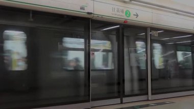 Ho Man Tin, Hong Kong - 6 Haziran 2025: MTR tren istasyonuna yaklaşan yolcular kapıdan çıkıyorlar