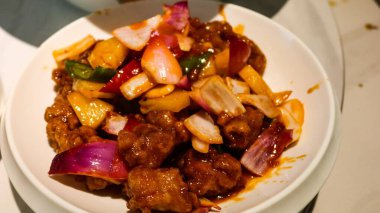 Kanton mutfağına yakın... tatlı ve ekşi kızarmış domuz kaburgası soğanlı, yeşil ve sarı biberli ve ananaslı beyaz tabakta