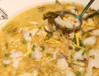 Çin Sichuan baharatlı ve ekşi haşlanmış balığın yanında lahana turşusu ve bir kaşık dolusu balık.