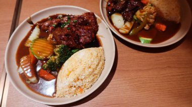 Japon domuz eti kıkırdağını pirinçle kaplayıp brokoli, havuç ve kabak da dahil olmak üzere sebzelerle servis edin.