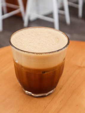 Soğuk kremalı, siyah bir kahvenin dikey fotoğrafı. Üstünde de fotokopi alanı olan yumuşak bir köpük tabakası var.