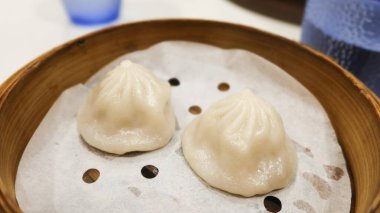 İki parça Çin Şanghay Dim Sum-Buharda pişmiş domuz çorbası bambu buharlı buharlı hamur köftesi.