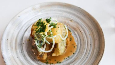 Kızarmış balık filetosunu soğan turşusuyla kaplayın, soğanla süsleyin ve lezzetli bir sosla servis edin, sade gri bir tabakta fotokopi alanı ile sunun.