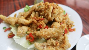 Kanton yemeklerine yakın, Bombay ördeği balığı ve beyaz tabakta baharatlı tuz.