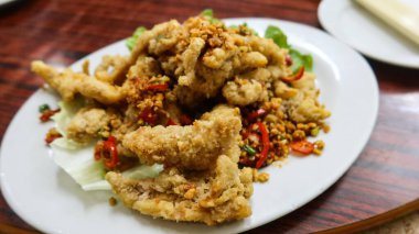 Kanton yemeklerine yakın, Bombay ördeği balığı ve beyaz tabakta baharatlı tuz.