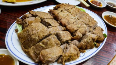 Kanton usulü taro ördeği yakın plan, Taro ile kavrulmuş çıtır ördek, taro kökünden bir battaniyeye sarılmış nemli ördek.