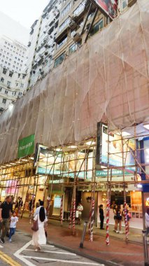 Causeway Körfezi, Hong Kong - 18 Temmuz 2025: Binanın dış tarafındaki bambu iskelesinin dikey fotoğrafı ve Hong Kong takımyıldızında yaygın olarak kullanılan beyaz güvenlik ağı