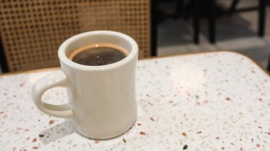 Sıcak bir kahveyi klasik bir beyaz fincanla fotokopi alanı olan trend bir terrazzo masasında kapatıyoruz.