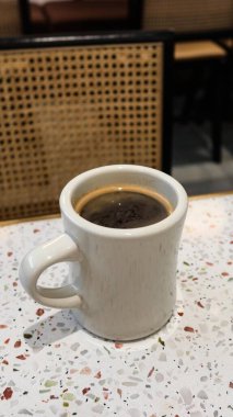 Sıcak bir kahveyi klasik bir beyaz fincanla fotokopi alanı olan trend bir terrazzo masasında kapatıyoruz.