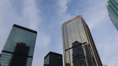 Amirallik, Hong Kong - 27 Haziran 2025: A sınıfı ofis gökdelenleri Lippo Merkez, Bank of America Tower ve Cheung Kong Centre da dahil olmak üzere mavi gökyüzünde alçak açılı cephe