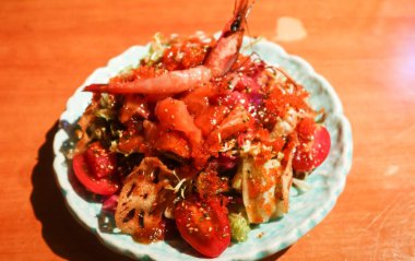 Japon saşimi deniz ürünleri salatasını, vişneli domates, salata, çiğ yengeç eti, istiridye, somon ve karidesleri fotokopi alanı olan bir tabağa koy.