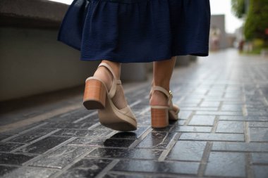 Topuklu ve mavi elbiseli beyaz kadın