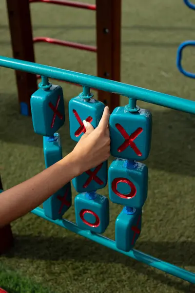Renkli bir çocuk parkında Tic Tac toe oynayan bir kızın yakın plan görüntüsü