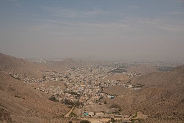 Açık ve güneşli bir günde Peru 'nun ıssız dağlarının ortasındaki kuru nüfuslu bir vadi şehrinin havadan görünüşü.