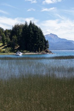 Mavi gölün dikey görüntüsü, içinde yüzen bir tekne var.